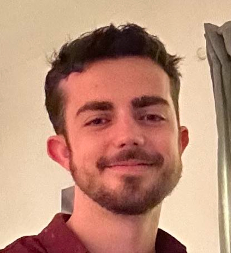 Photo portrait d’un jeune homme souriant, prise en intérieur dans une ambiance chaleureuse. Ce visuel peut illustrer une présentation professionnelle, une page “à propos” ou une communication humaine mettant en avant la proximité, la confiance et l’authenticité. Image idéale pour représenter un responsable, un intervenant ou un porteur de projet dans le secteur des services à la personne.